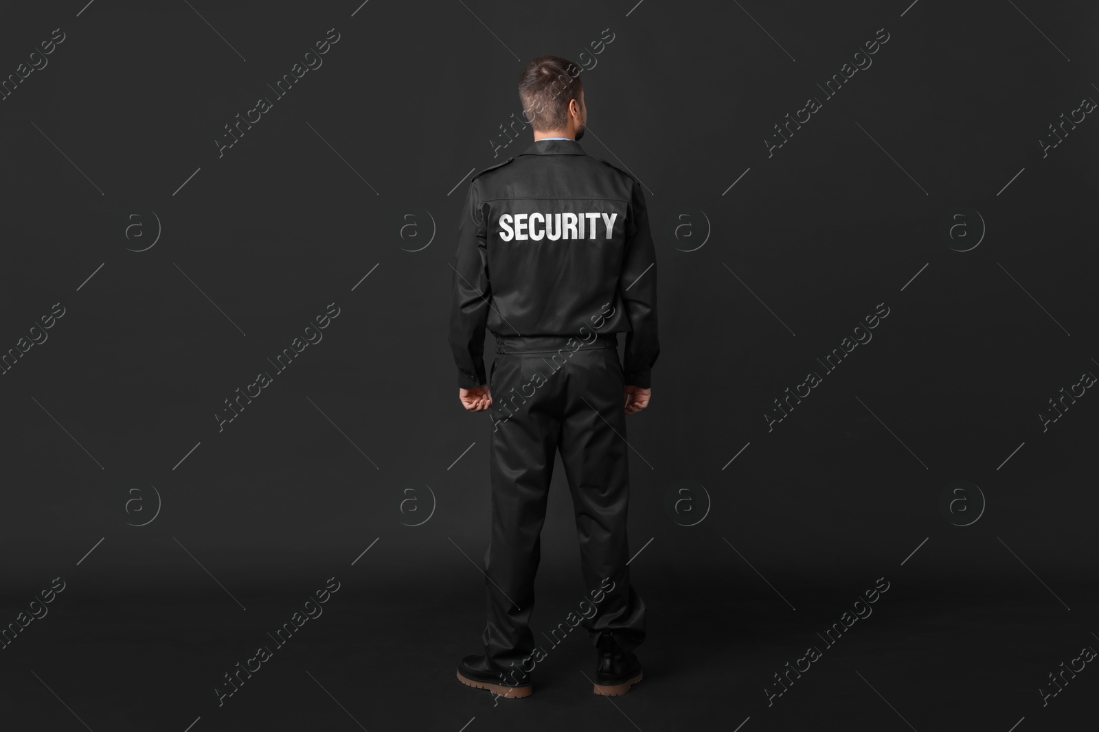 Photo of Security guard in uniform on black background, back view