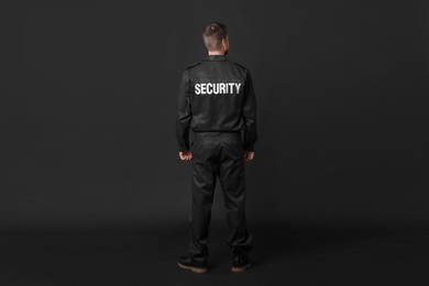 Photo of Security guard in uniform on black background, back view