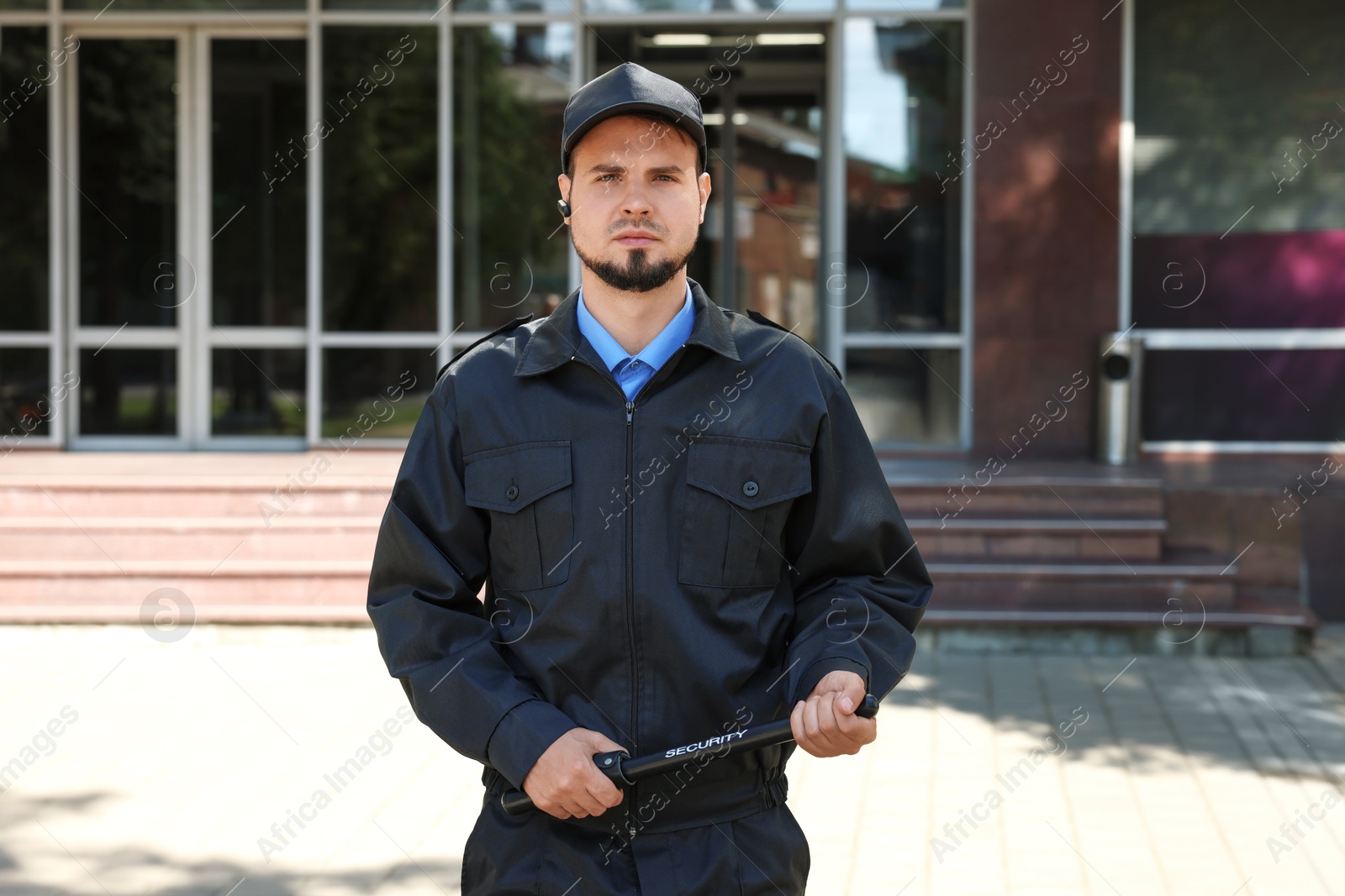 Photo of Security guard in uniform with baton outdoors