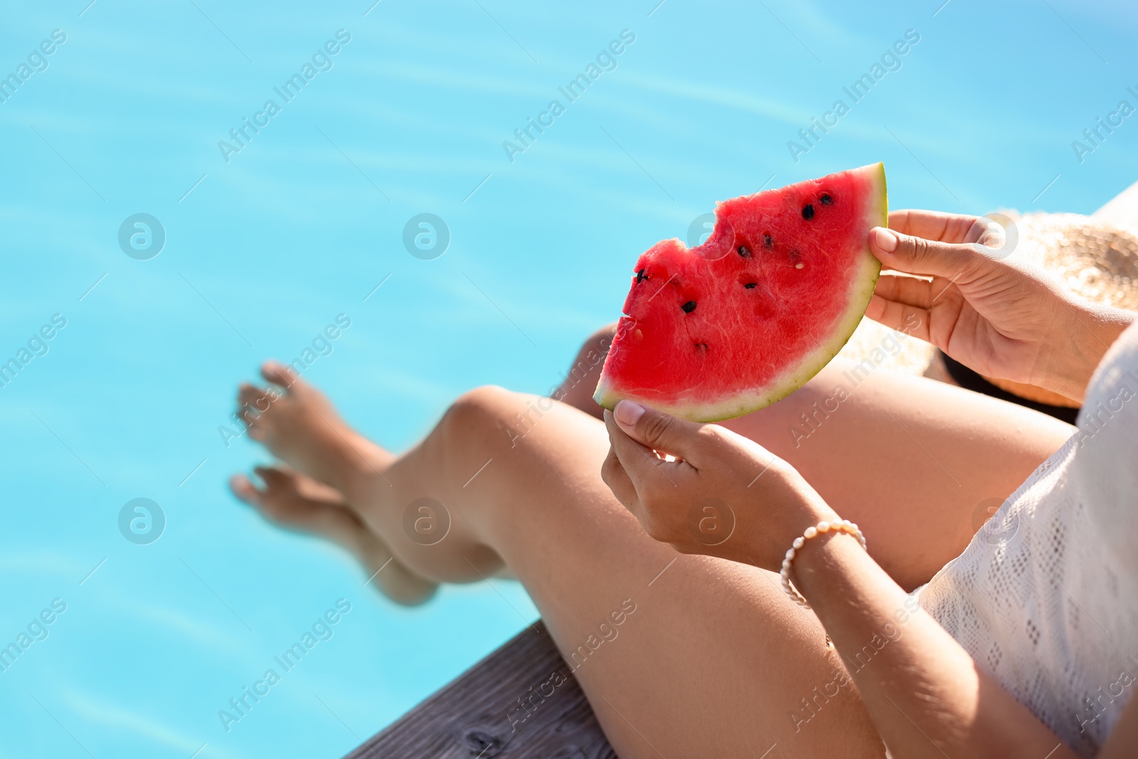 Photo of Woman with slice of juicy watermelon near swimming pool outdoors, closeup