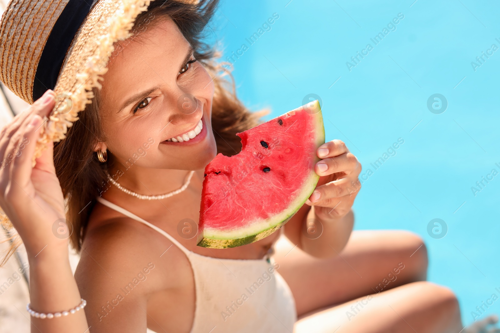 Photo of Happy woman with slice of juicy watermelon near swimming pool outdoors