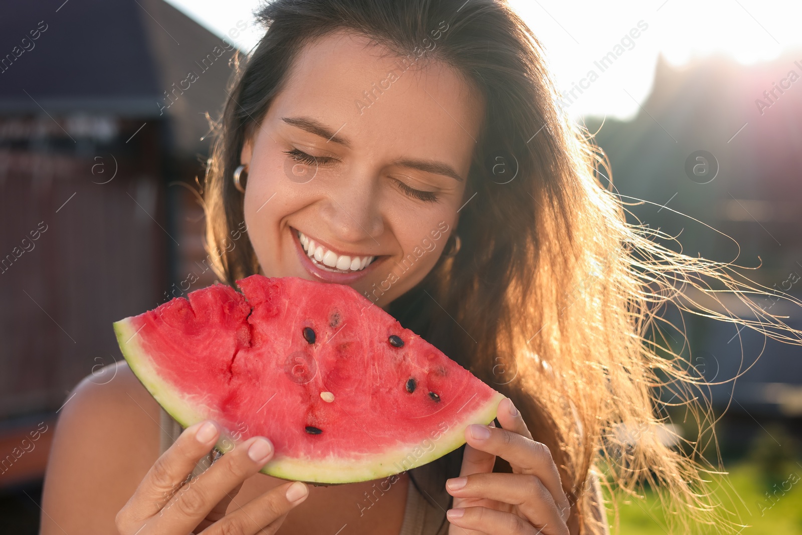 Photo of Happy woman with slice of juicy watermelon outdoors