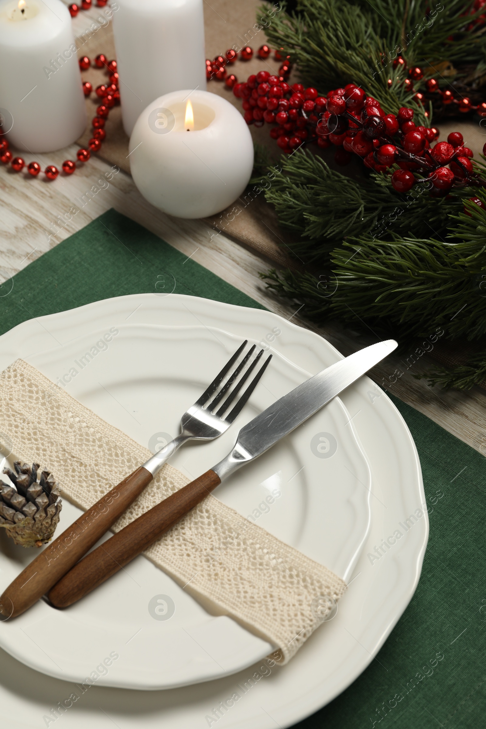 Photo of Plates, cutlery and Christmas decor on wooden table