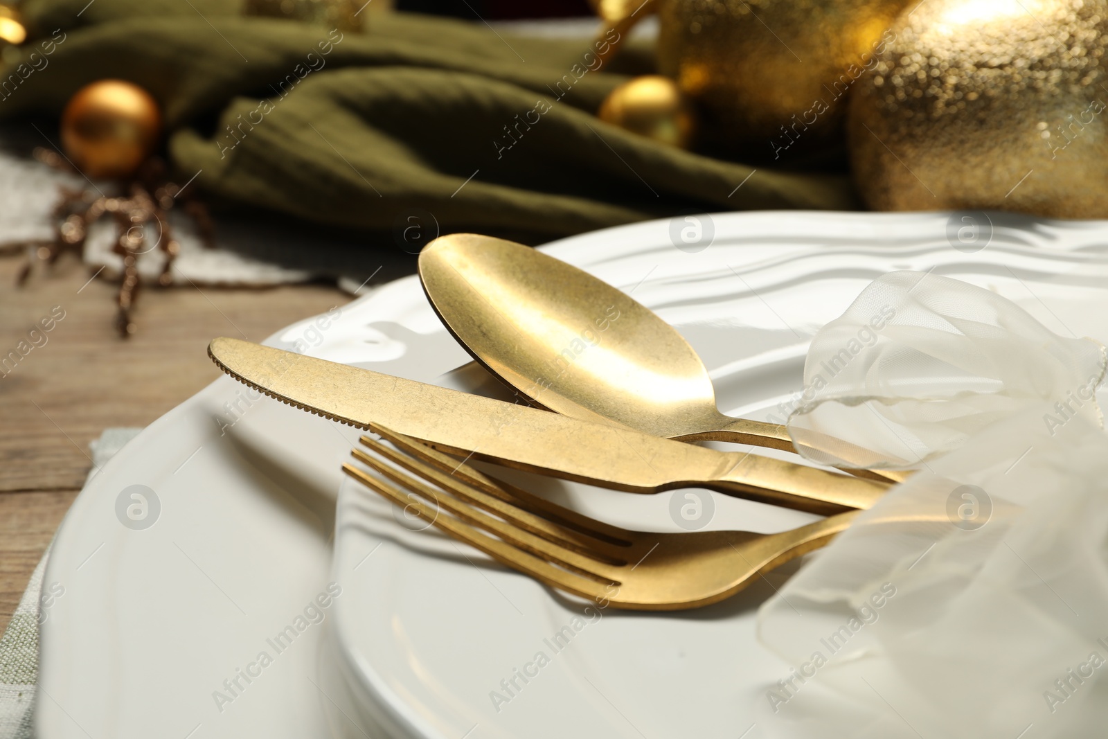 Photo of Plates, cutlery and Christmas decor on table, closeup