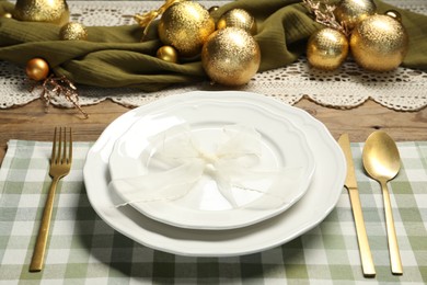 Photo of Plates, cutlery and Christmas decor on wooden table