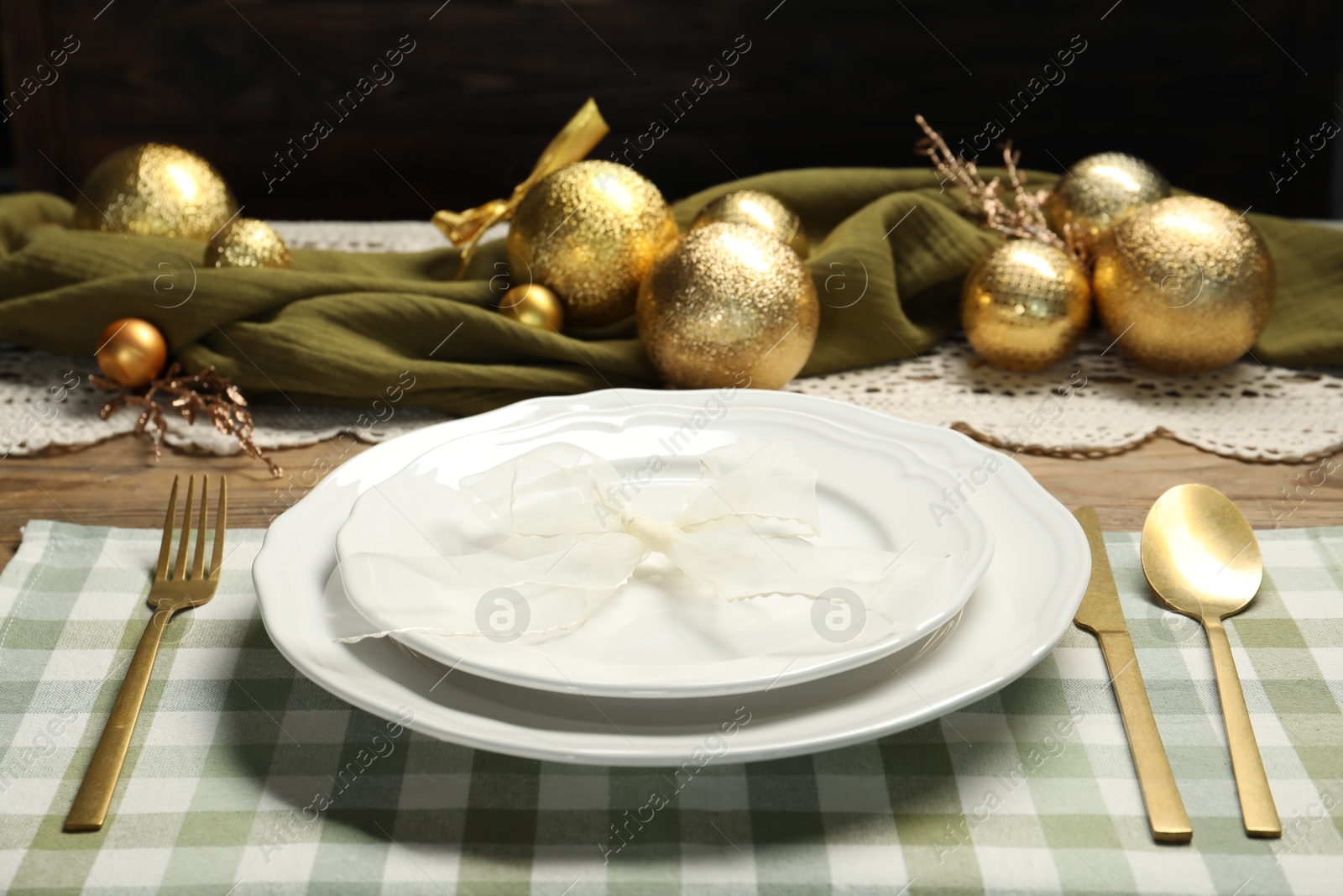 Photo of Plates, cutlery and Christmas decor on wooden table