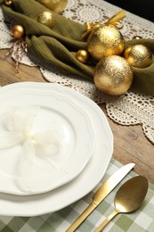 Photo of Plates, cutlery and Christmas decor on wooden table