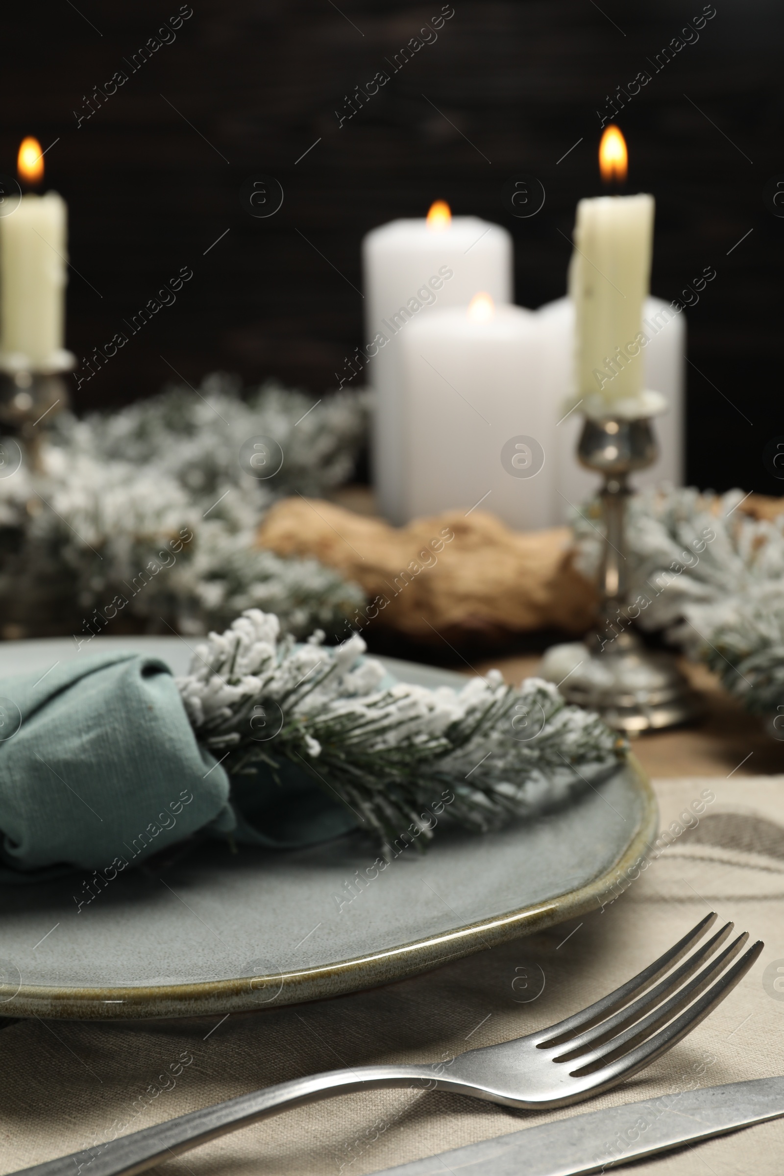 Photo of Plate, cutlery and Christmas decor on table, closeup