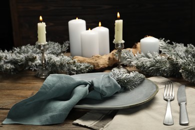 Photo of Plate, cutlery and Christmas decor on wooden table