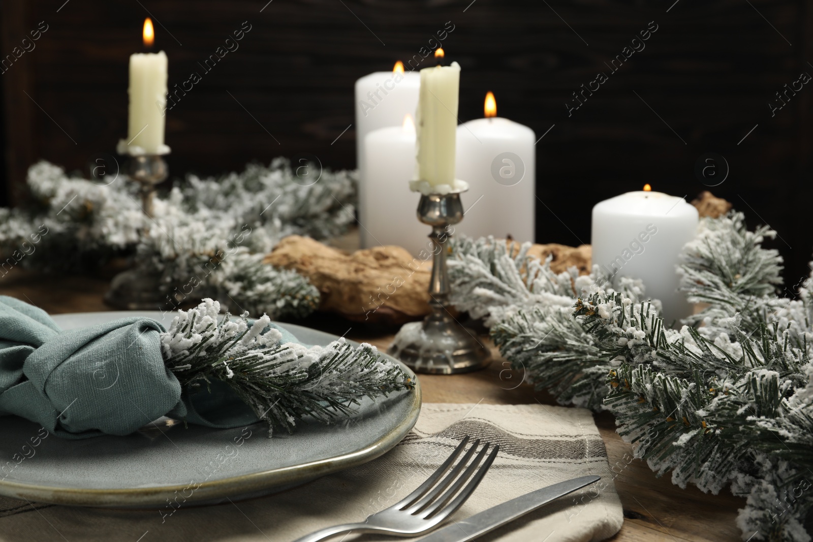 Photo of Plate, cutlery and Christmas decor on wooden table, closeup