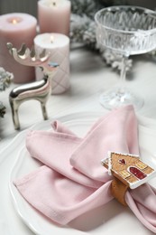 Photo of Plates, napkin, glass and Christmas decor on table, closeup