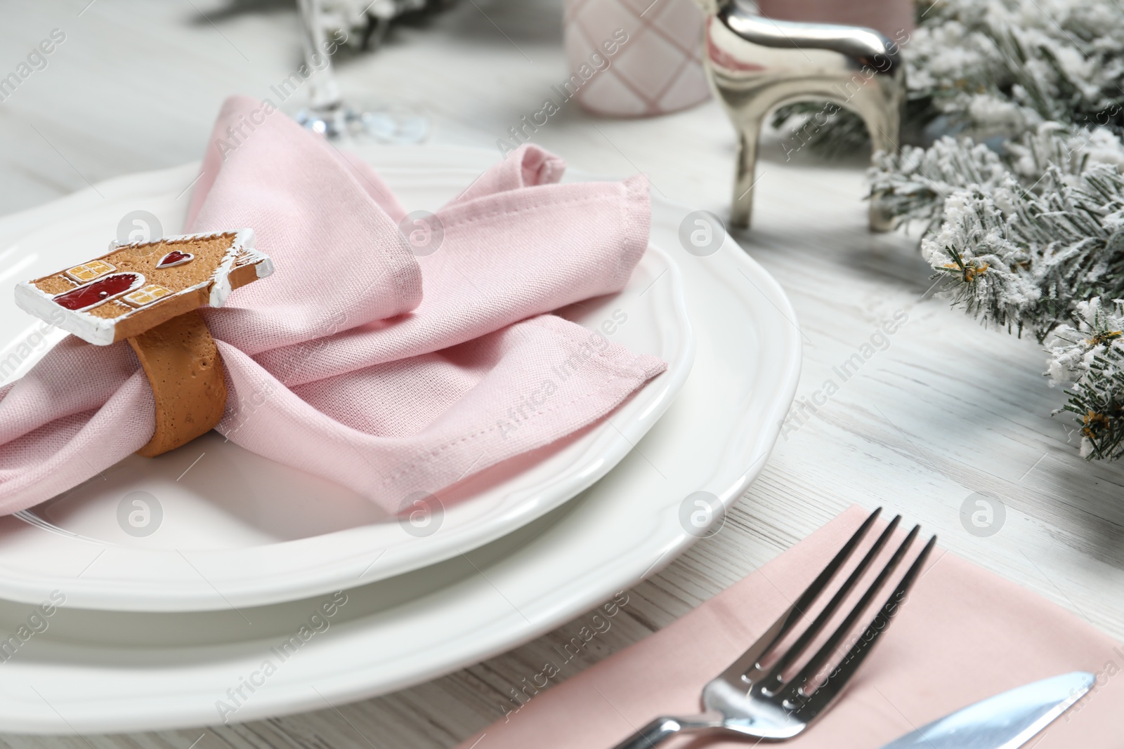 Photo of Plates, napkin, cutlery and Christmas decor on wooden table, closeup