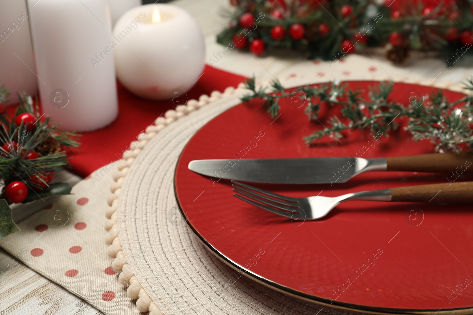 Photo of Plate, cutlery and Christmas decor on table, closeup