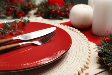 Photo of Plate, cutlery and Christmas decor on table, closeup