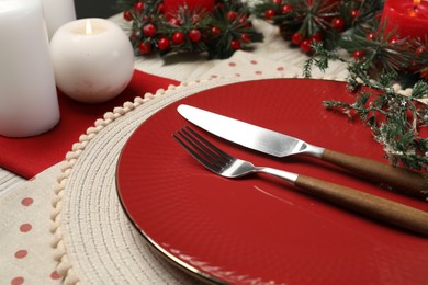 Photo of Plate, cutlery and Christmas decor on table, closeup