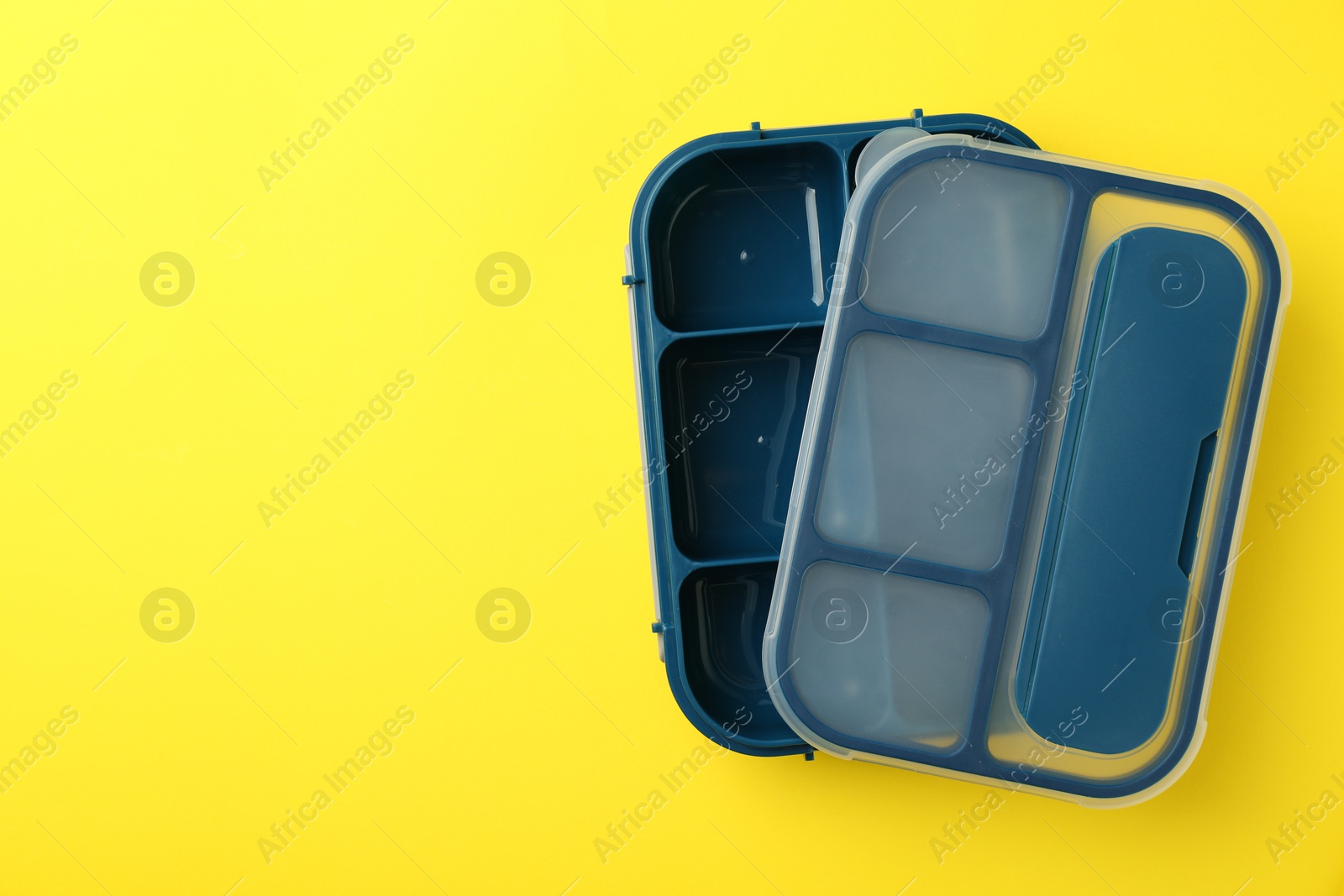 Photo of Empty lunch box on yellow background, top view. Space for text