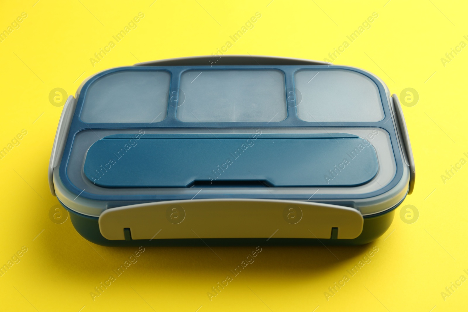 Photo of Empty plastic lunch box on yellow background, closeup