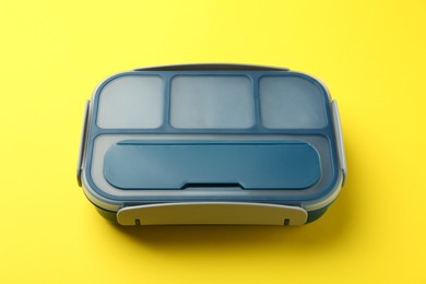 Photo of Empty plastic lunch box on yellow background