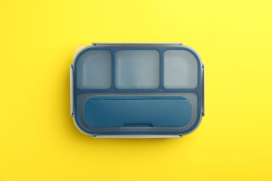 Photo of Empty lunch box on yellow background, top view