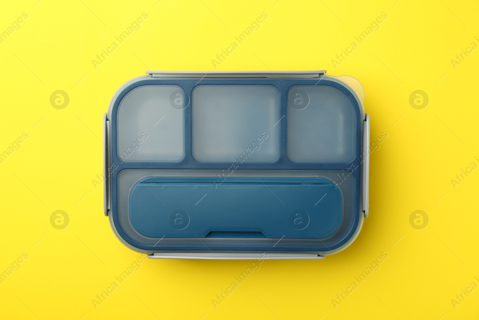 Photo of Empty lunch box on yellow background, top view