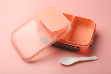 Photo of Empty lunch box and spoon on pink background