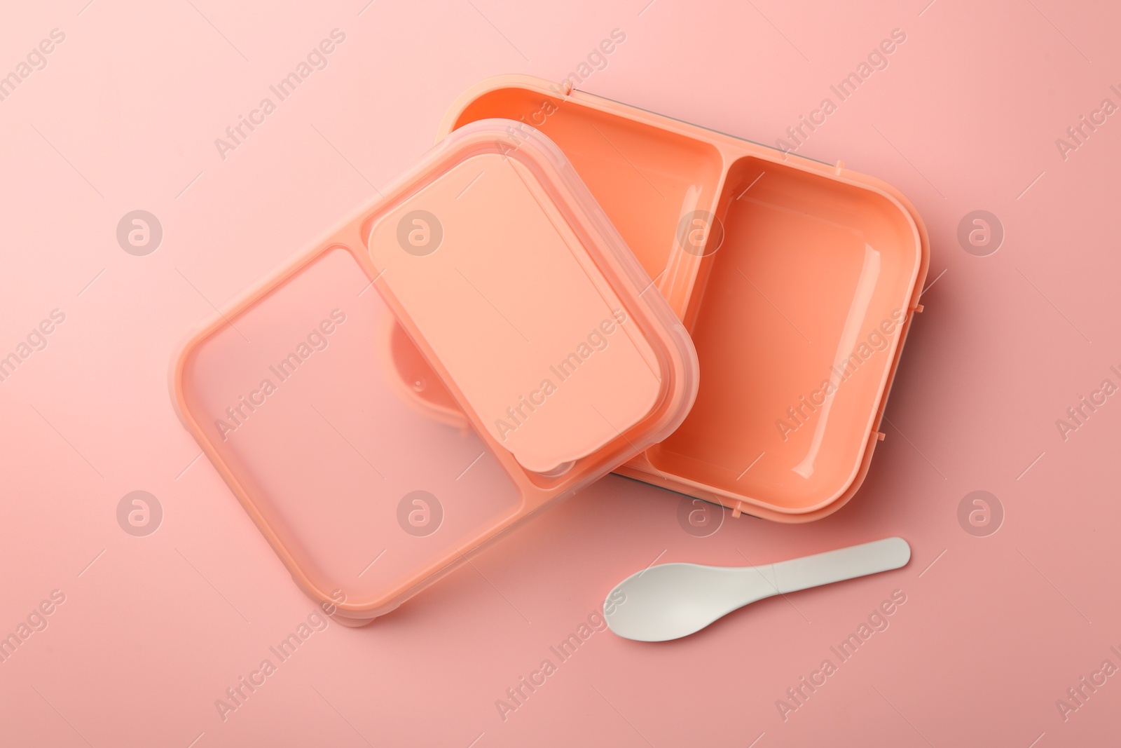 Photo of Empty lunch box and spoon on pink background, top view