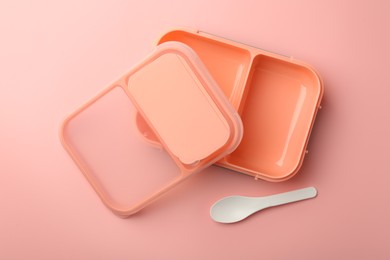 Photo of Empty lunch box and spoon on pink background, top view