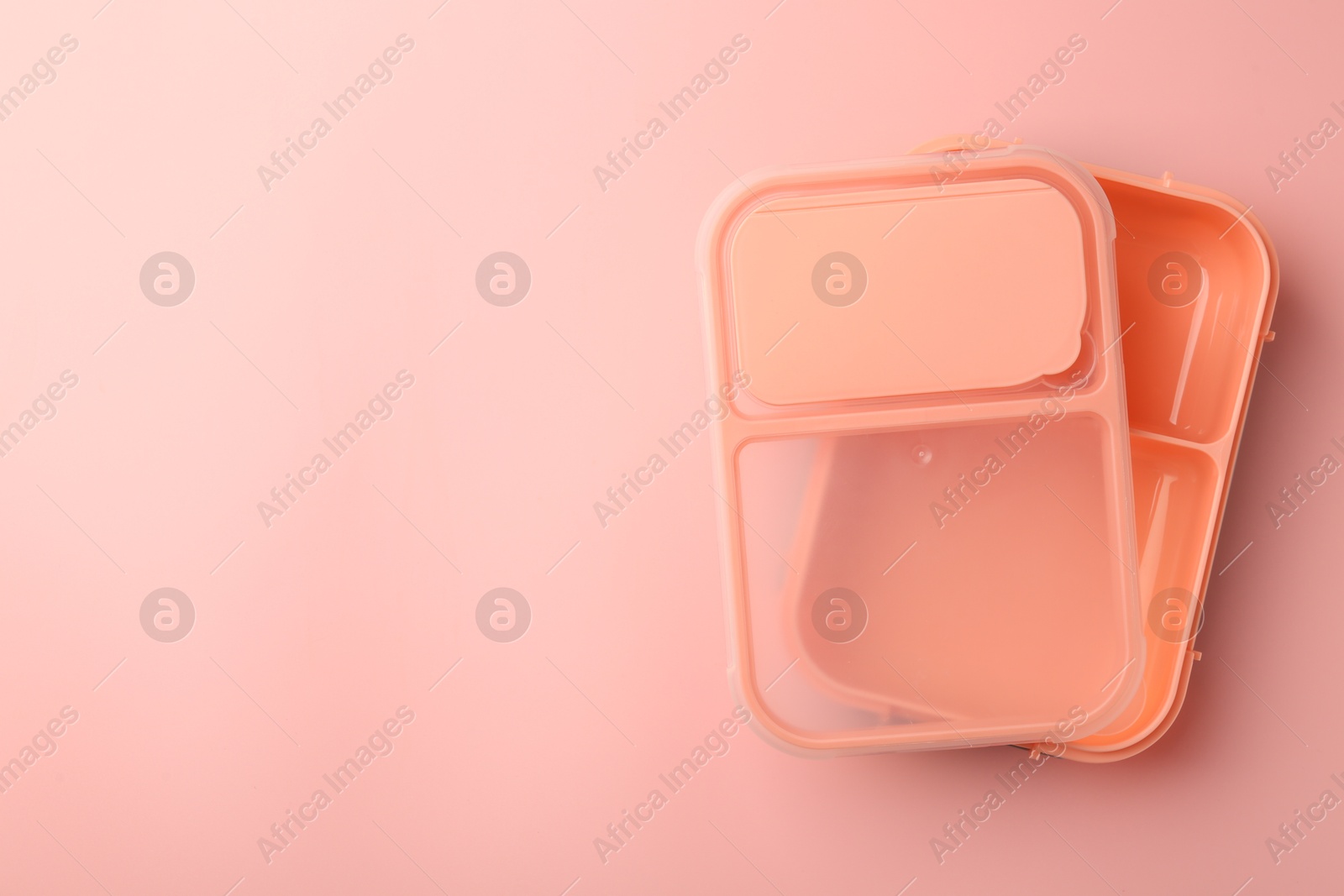 Photo of Empty lunch box on pink background, top view. Space for text