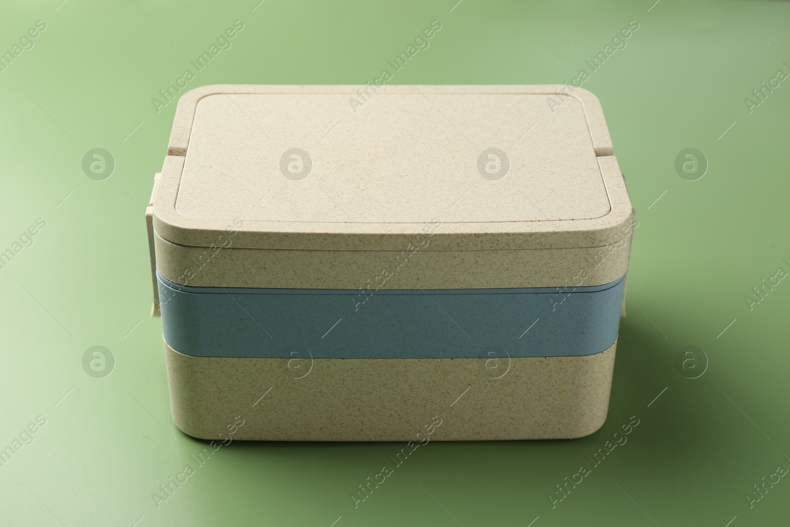 Photo of New plastic lunch box on green background