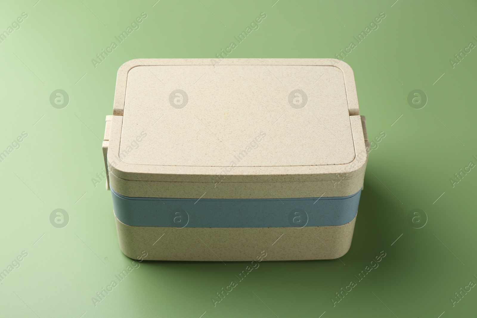 Photo of New plastic lunch box on green background