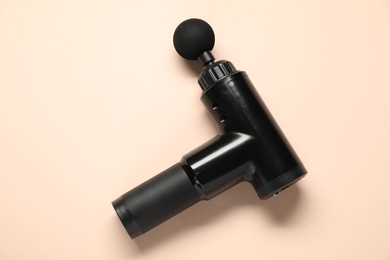 Photo of One black percussive massager on beige background, top view