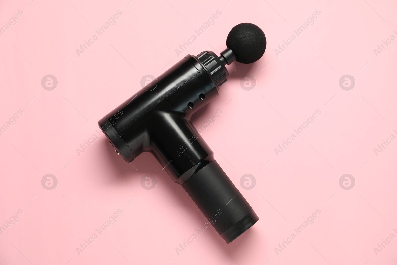 Photo of One black percussive massager on pink background, top view