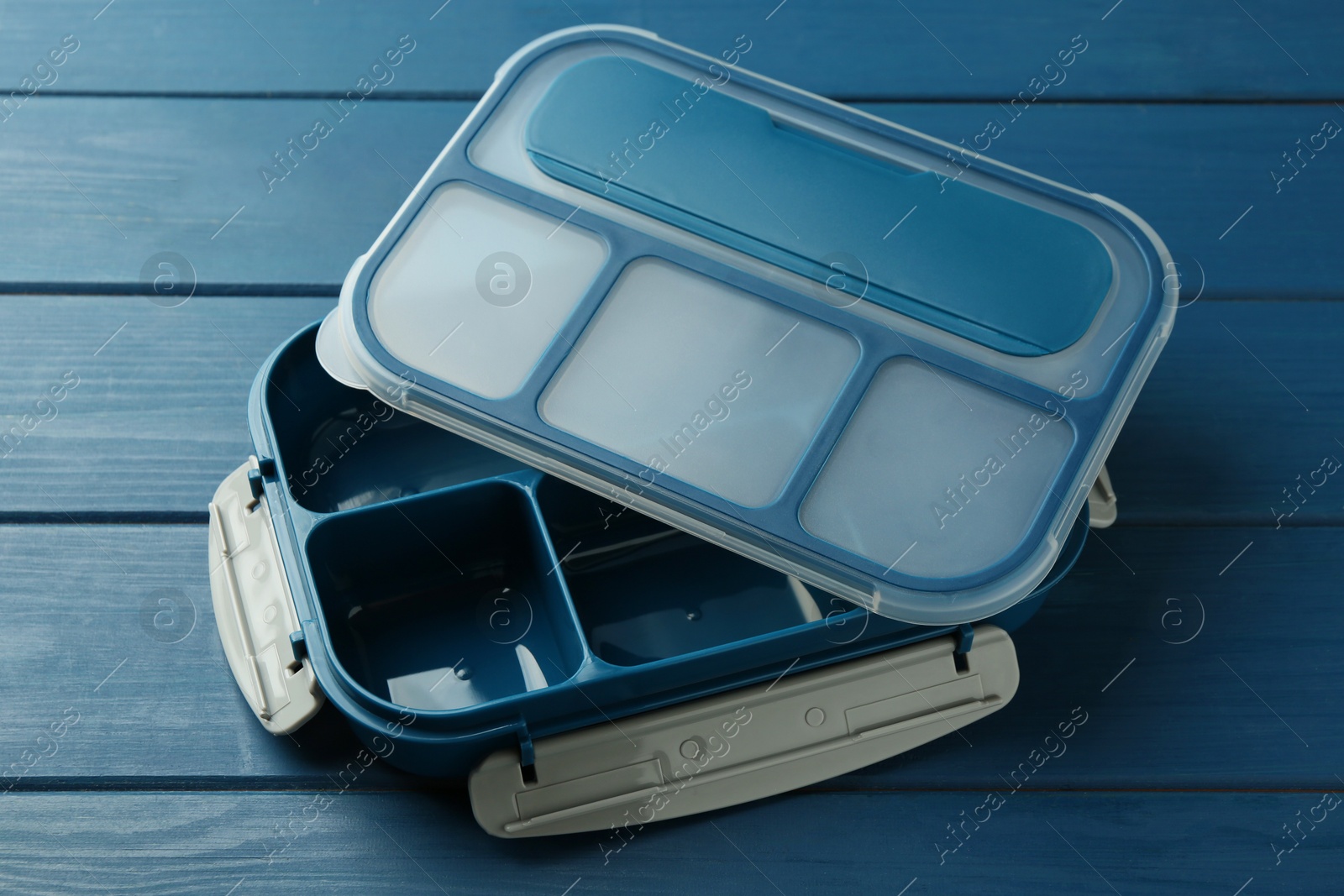 Photo of Empty lunch box on blue wooden table