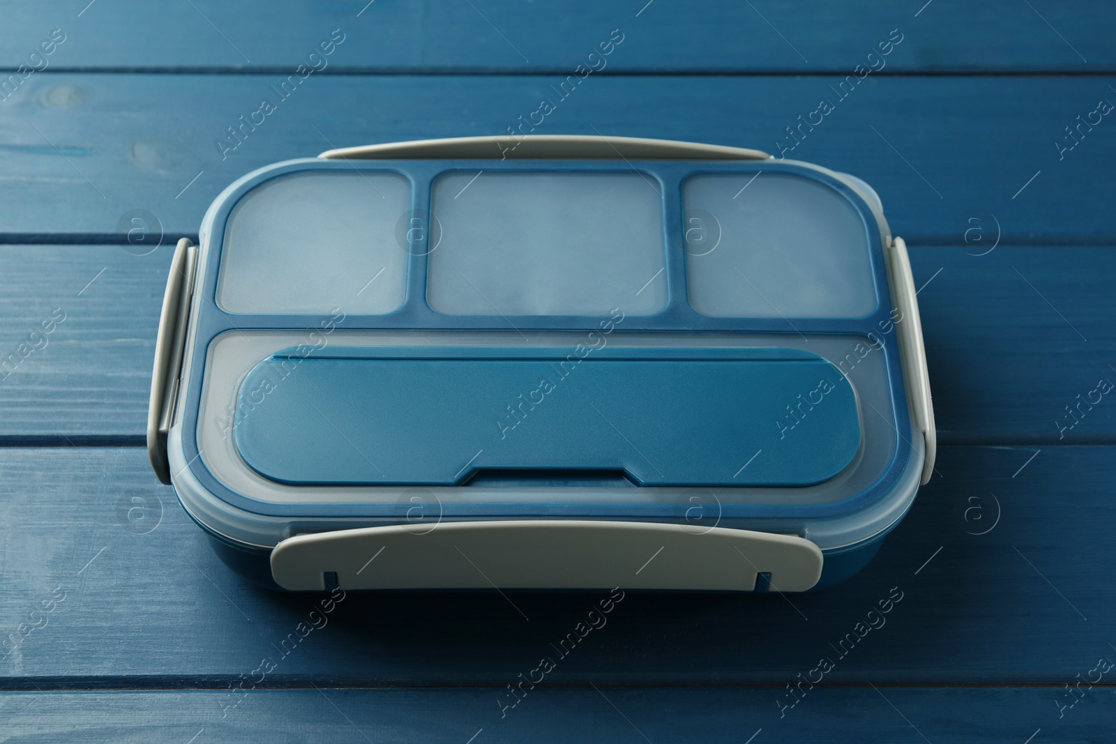 Photo of Empty lunch box on blue wooden table