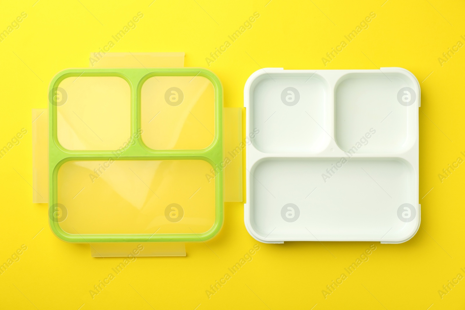 Photo of Plastic lunch box and lid on yellow background, top view