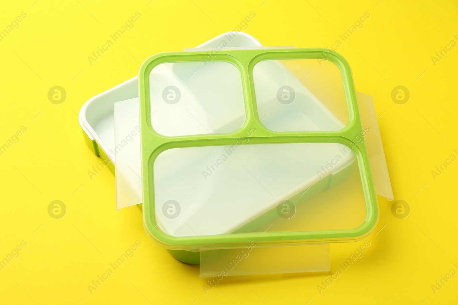 Photo of Empty plastic lunch box on yellow background