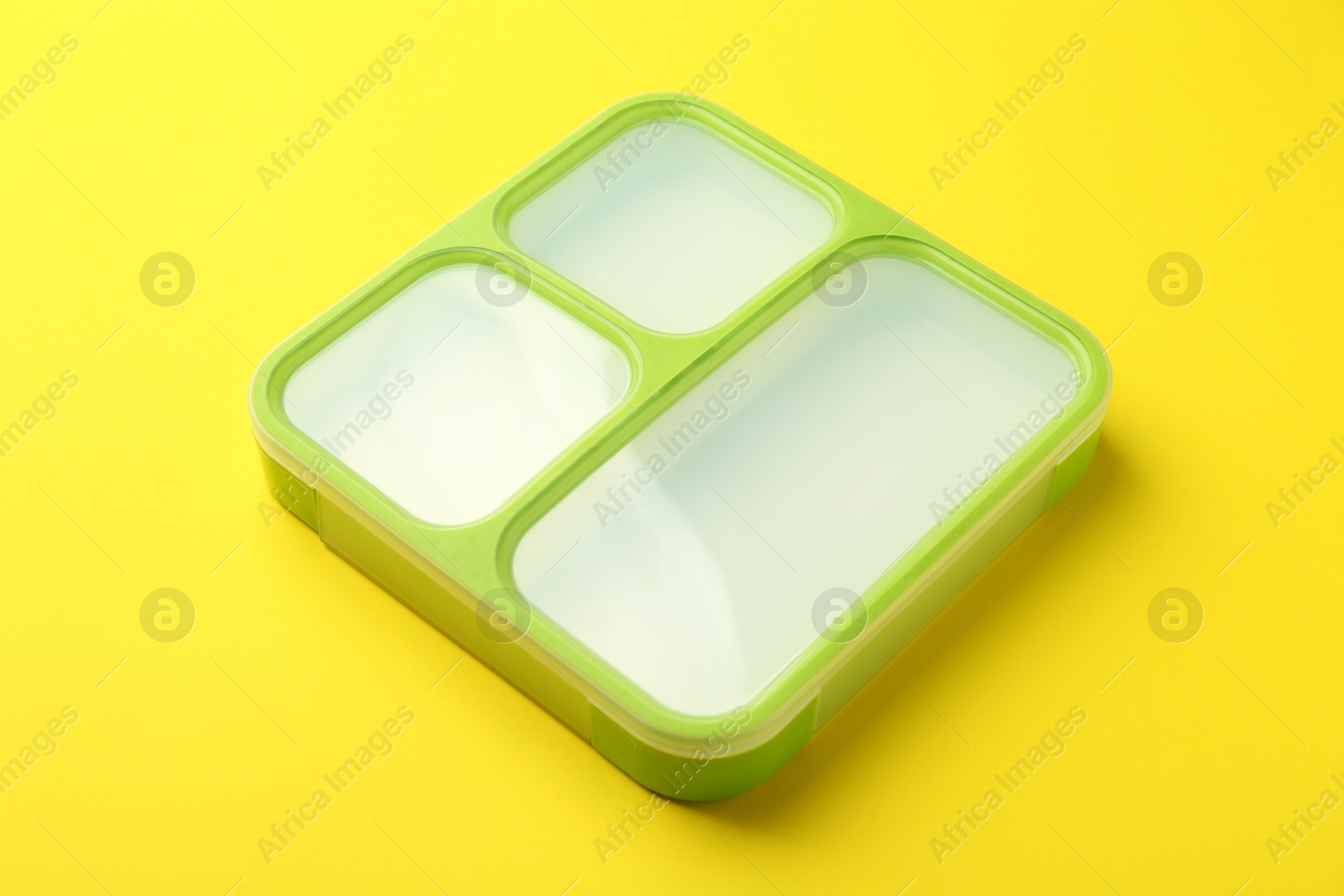 Photo of Empty plastic lunch box on yellow background