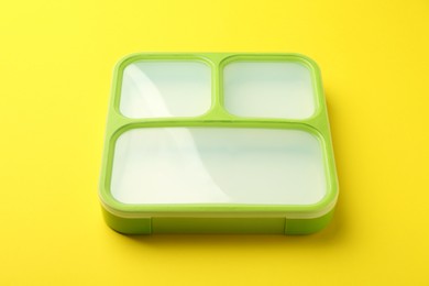 Photo of Empty plastic lunch box on yellow background