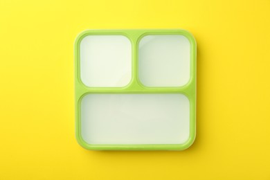 Photo of Empty lunch box on yellow background, top view