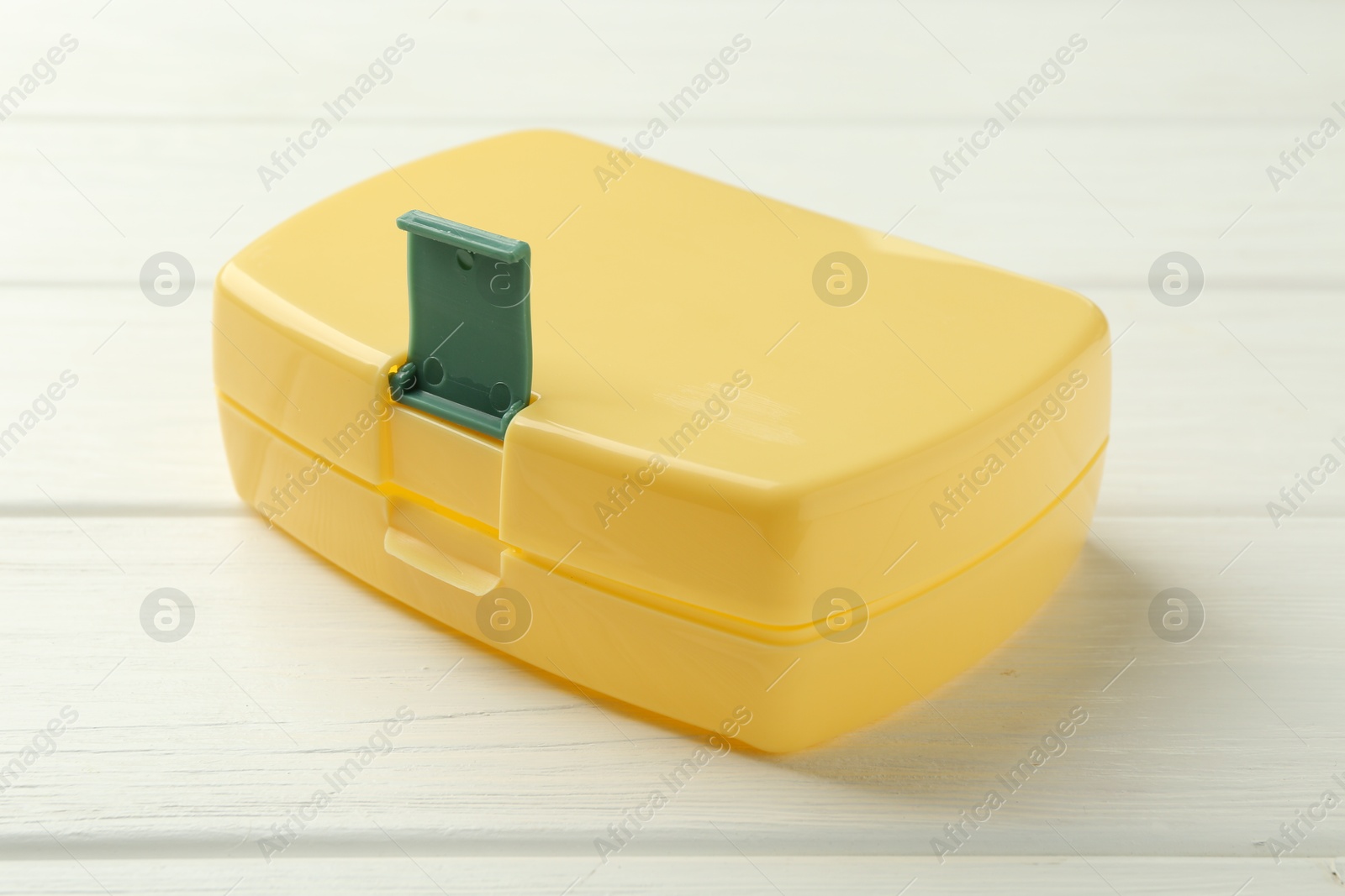 Photo of Yellow lunch box on white wooden table