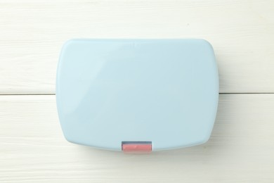 Photo of Light blue lunch box on white wooden table, top view