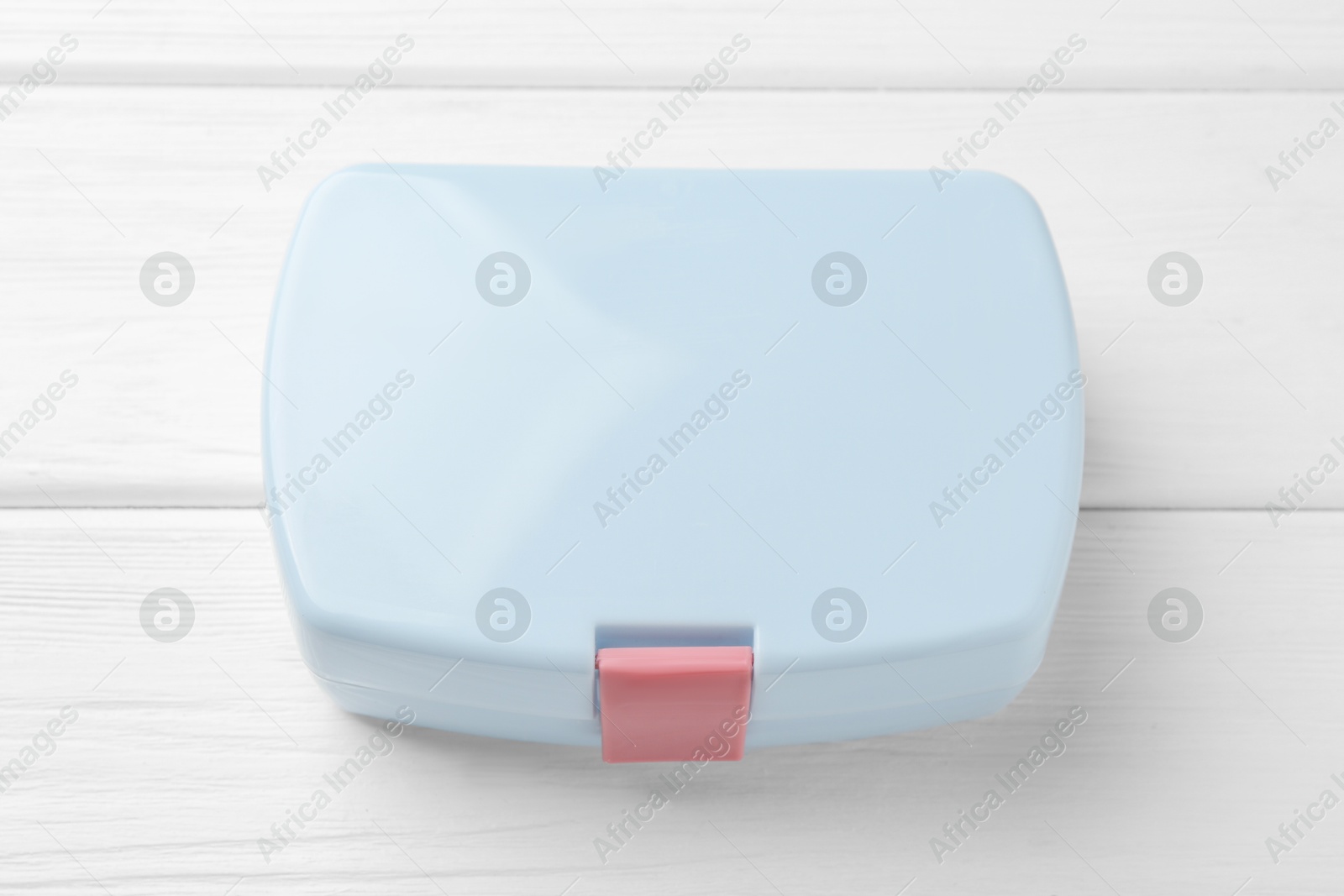 Photo of Light blue lunch box on white wooden table