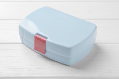 Photo of Light blue lunch box on white wooden table