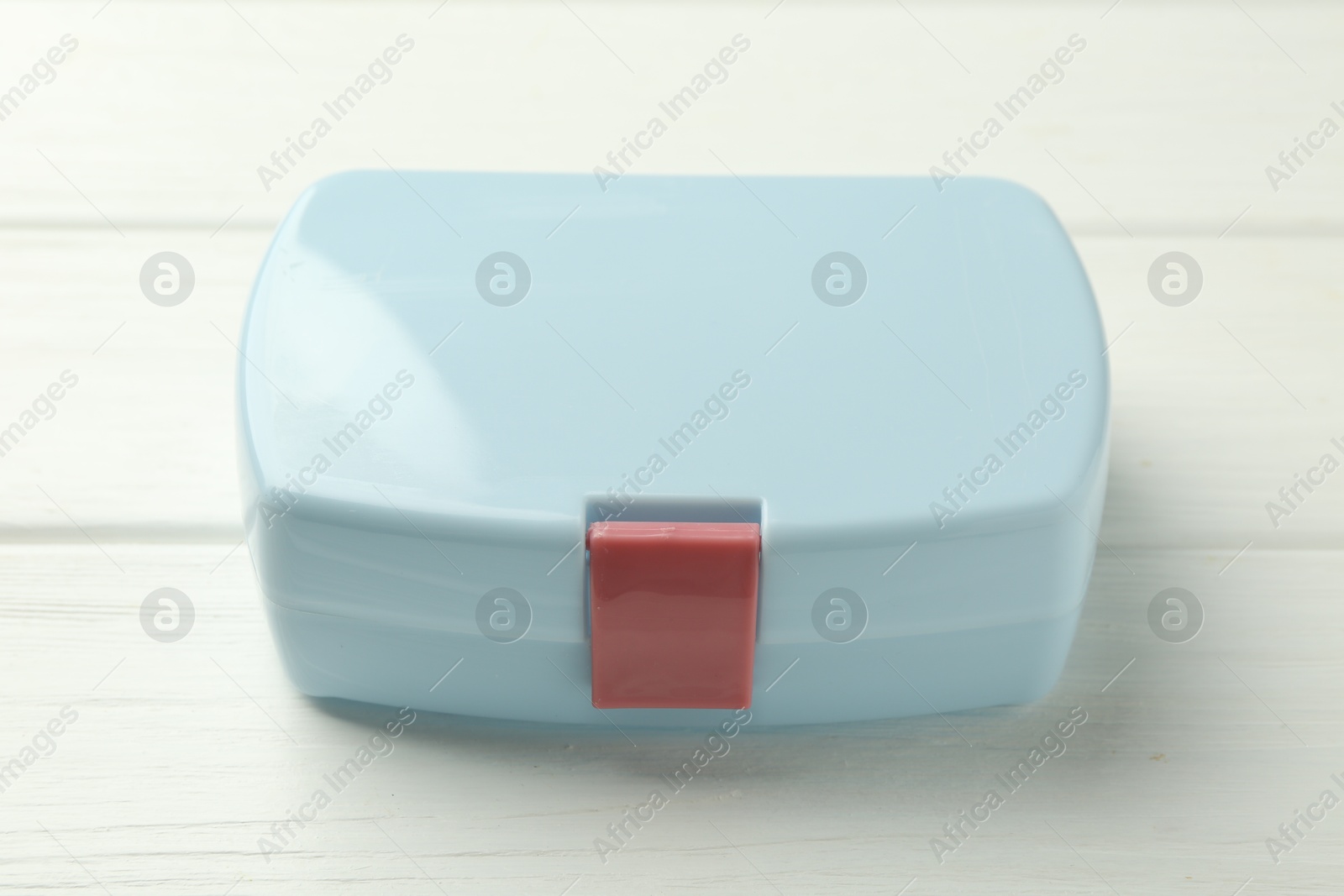 Photo of Light blue lunch box on white wooden table