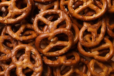 Photo of Many delicious pretzel crackers as background, top view