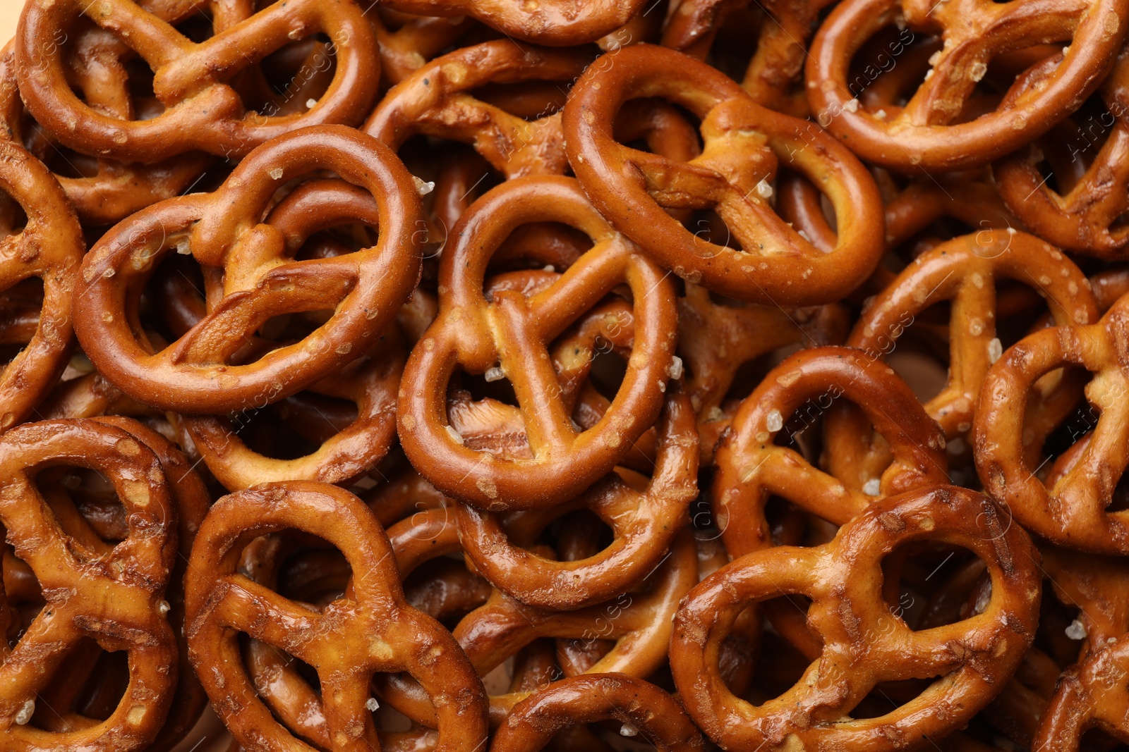 Photo of Many delicious pretzel crackers as background, top view