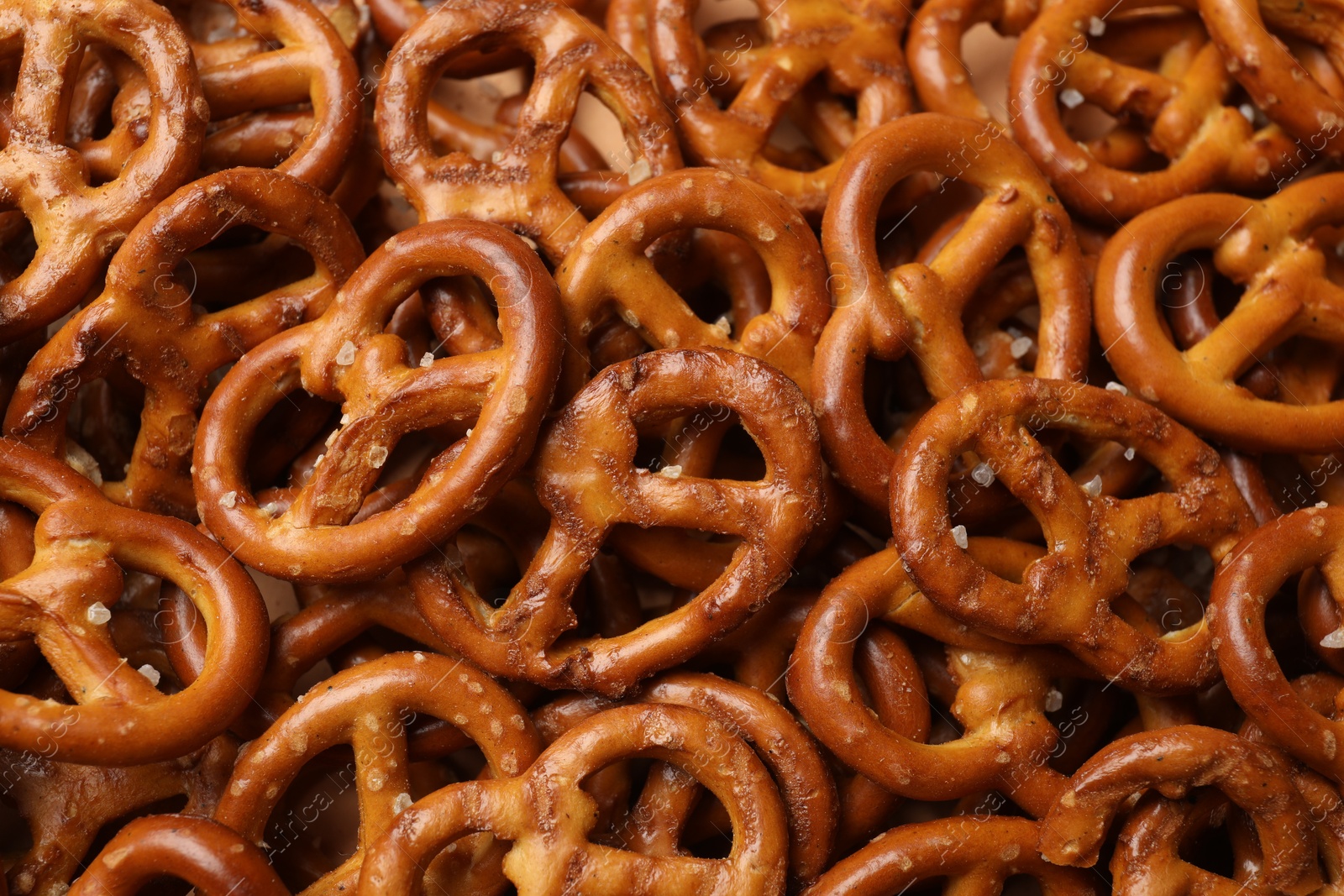 Photo of Many delicious pretzel crackers as background, top view