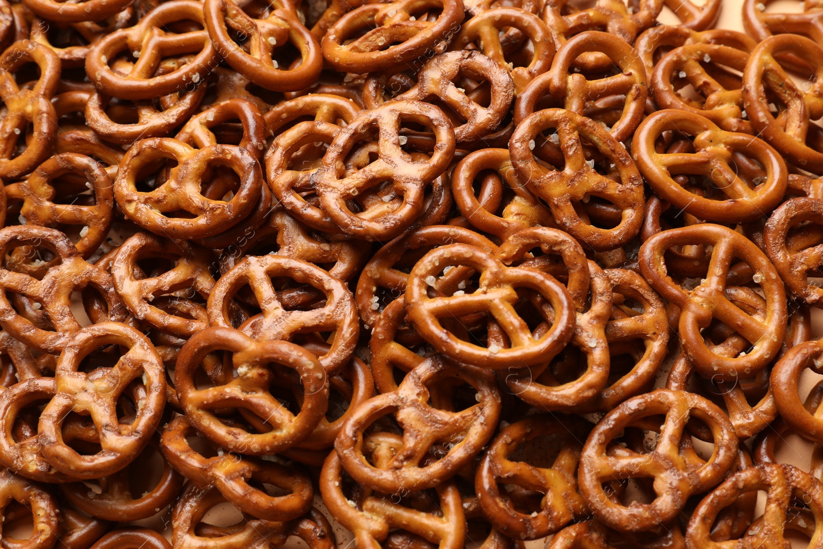 Photo of Many delicious pretzel crackers as background, top view