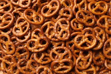 Photo of Many delicious pretzel crackers as background, top view