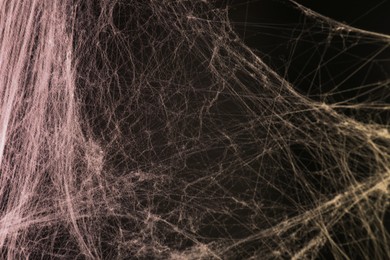 Cobweb against black background, toned in red and orange colors